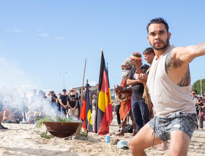 Traditional Aboriginal smoking ceremony on Bather's Beach with a fire pit and two male perfomers