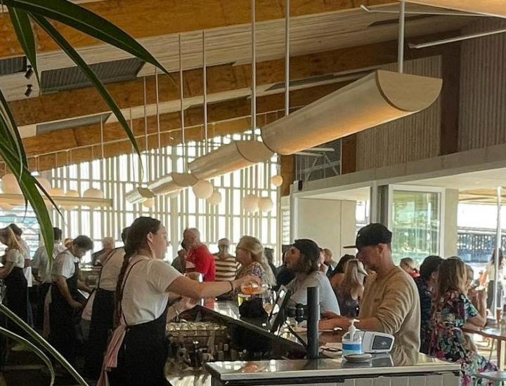 bar staff serving drinks in light waterfront restaurant