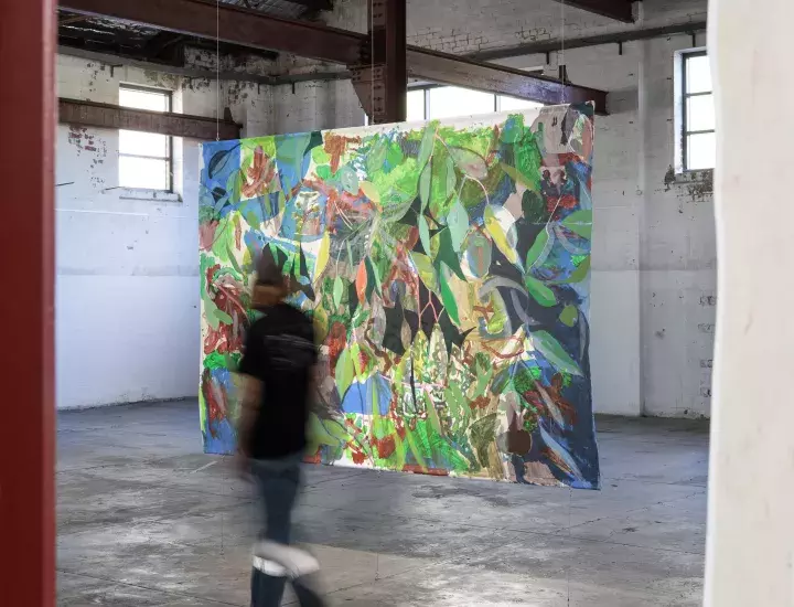 A brightly coloured art work on display in a warehouse.
