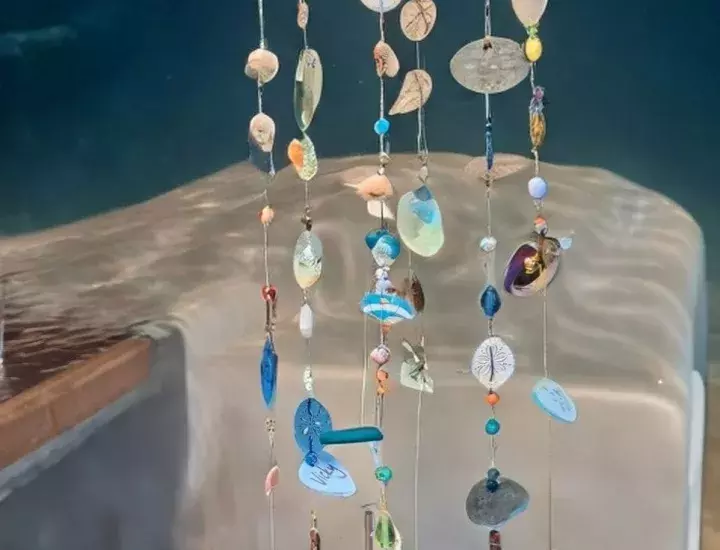 An elaborate wind chime filled with shells of various colours.