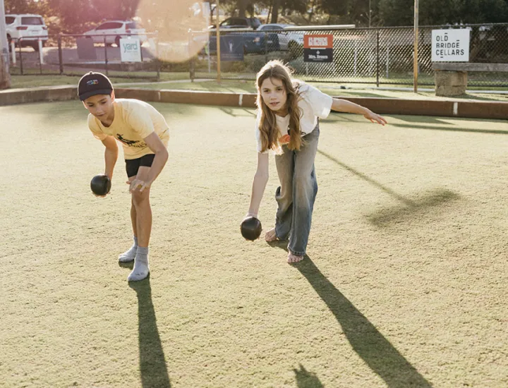 two kids playing lawn bowls 