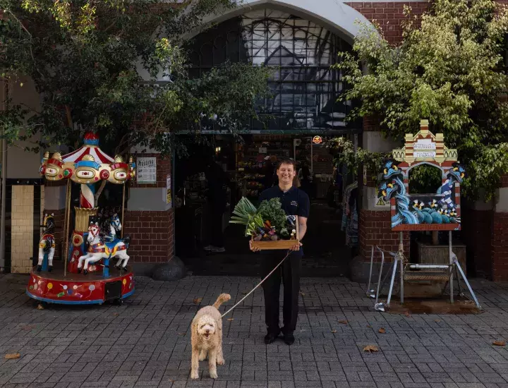 dog on a lead outside of a market stall 