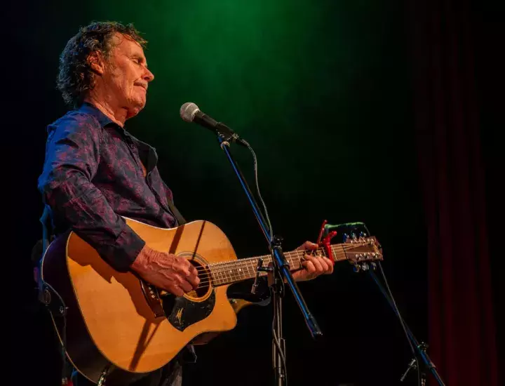 man playing guitar on a stage