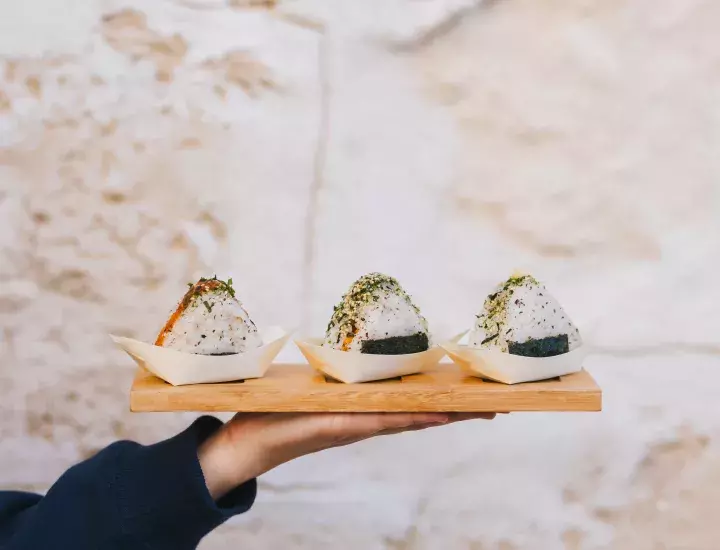 three signature truffle dishes on a wooden plate being held on a hand