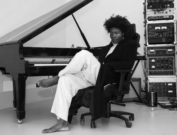 an artist sitting at a piano in black and white