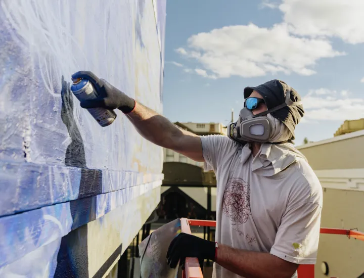 an artist painting on a wall with blue and white paint