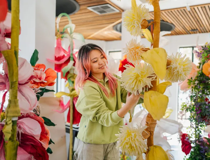 a woman making beautiful colourful paper flowers 